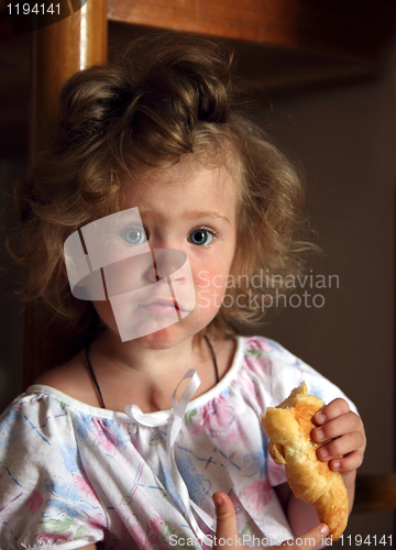 Image of little girl eating croissant