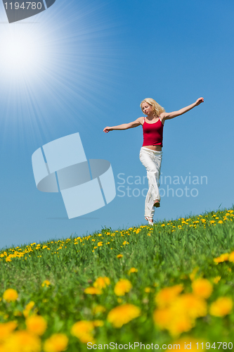 Image of young woman in red outfit having fun on meadow