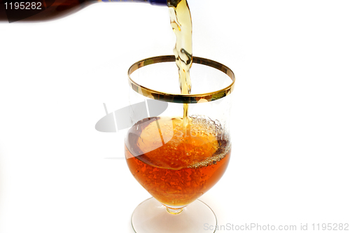 Image of Bottle filling a glass with brown liquid