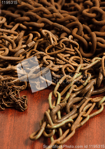 Image of Rusty chain on wooden board