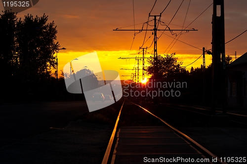Image of Sunset with traffic and rails in the suburbs