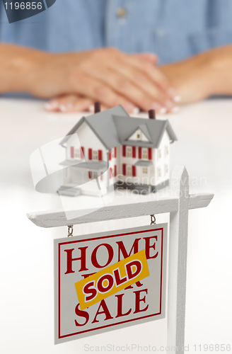 Image of Womans Hands Behind House and Sold Real Estate Sign