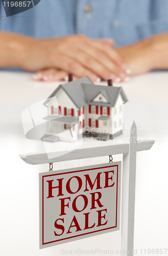 Image of Womans Hands Behind House and Real Estate Sign in Front