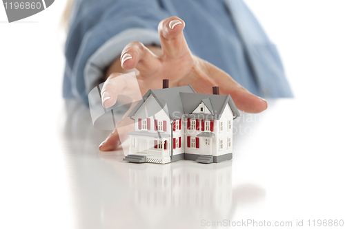 Image of Womans Hand Reaching for Model House on White