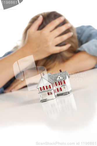 Image of Woman with Head in Hand Behind Model Home