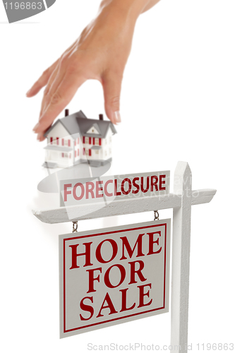 Image of Womans Hand Choosing Home with Foreclosure Real Estate Sign