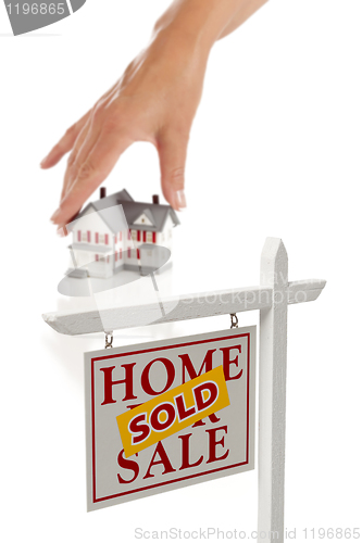 Image of Womans Hand Choosing Home with Sold Real Estate Sign