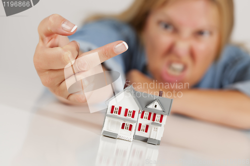 Image of Angry Woman Flipping The Bird Behind Model Home on White