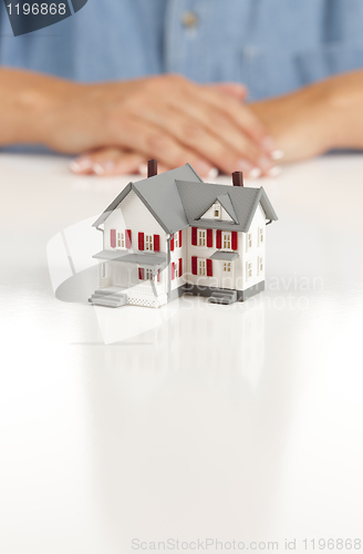 Image of Womans Folded Hands Behind Model House