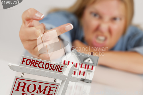 Image of Woman Flipping The Bird Behind Model Home and Foreclosure Sign