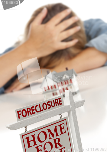 Image of Woman, Head in Hand Behind Model Home and Foreclosure Sign