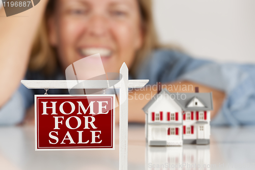 Image of Smiling Woman Behind Real Estate Sign House on a White Surface