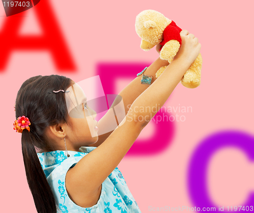 Image of Girl Holding Her Teddy Bear Up In The Air