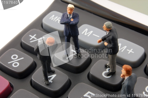 Image of toy business man on calculator isolated 