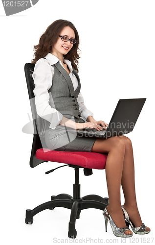 Image of Business brunette girl on a chair with a laptop