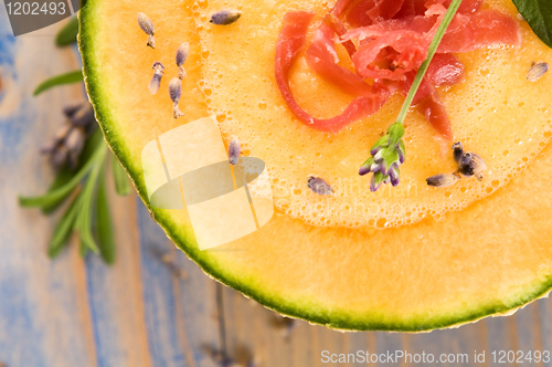 Image of fresh melon soup with parma ham and lavender flower