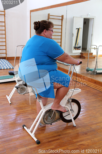 Image of overweight woman exercising on bike