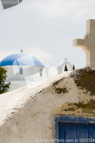 Image of ancient Greek Island church with cross blue dome church backgrou