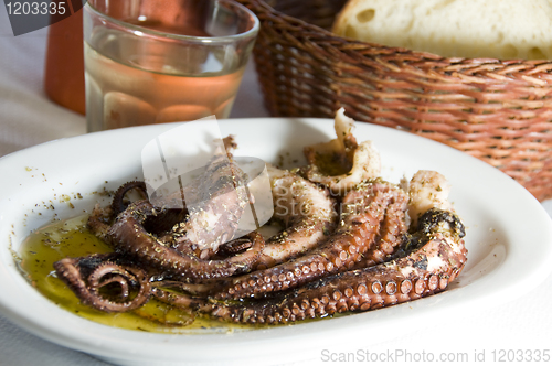 Image of marinated octopus with house wine Greek Island taverna specialty
