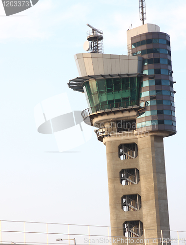 Image of air traffic control tower at an airport on a stormy looking day.