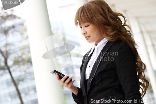 Image of beautiful business woman on the phone at modern building