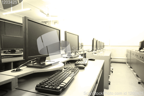 Image of workplace room with computers in row 