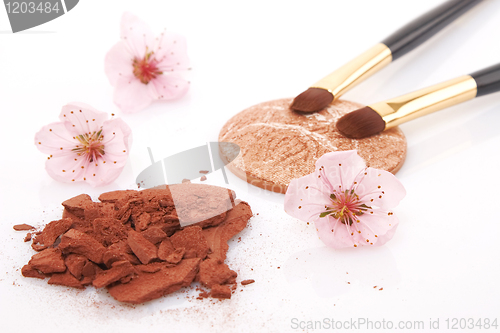 Image of brown powder for makeup and flowers