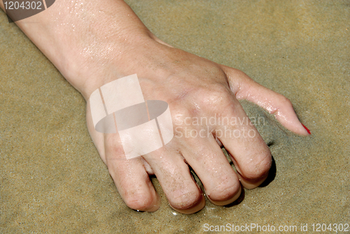 Image of Hand grabbing sand