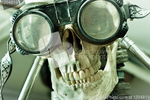 Image of Human skull with insane look and goggles (robot)