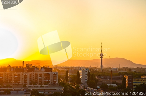 Image of City at dawn with apartments and tower and mountains