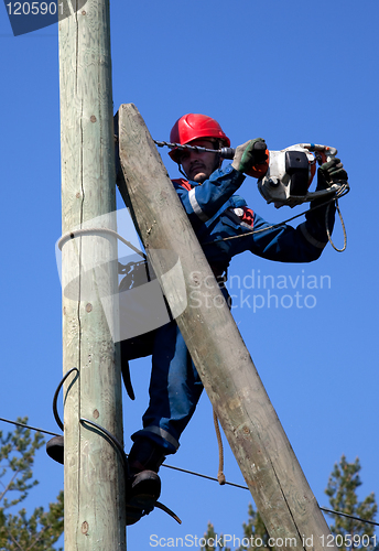 Image of Electrician on a pole makes installation work