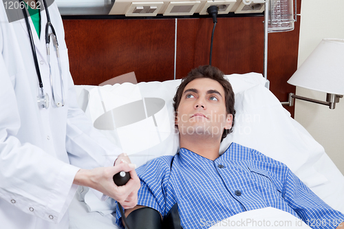 Image of Doctor checking patient's blood pressure