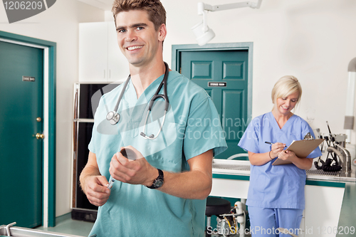 Image of Doctor with syringe while nurse taking down report