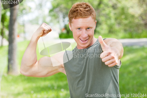 Image of Man flexing and showing thumbs-up sign