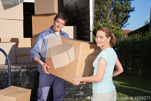 Image of Portrait of couple carrying cardboard box