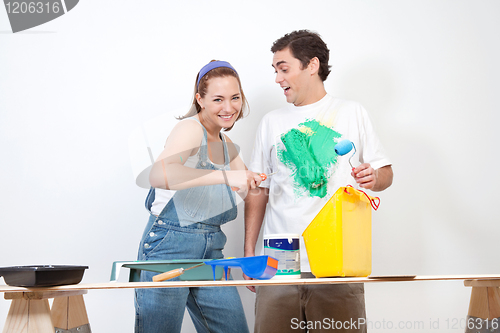 Image of Woman painting color on her boyfriend's shirt