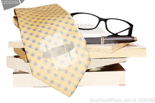 Image of Pen, lens, pile of books and tie 