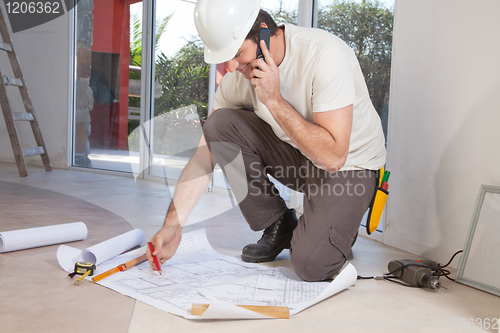 Image of Construction worker working on blueprint