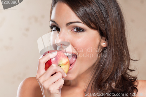 Image of Pretty young woman eating an apple
