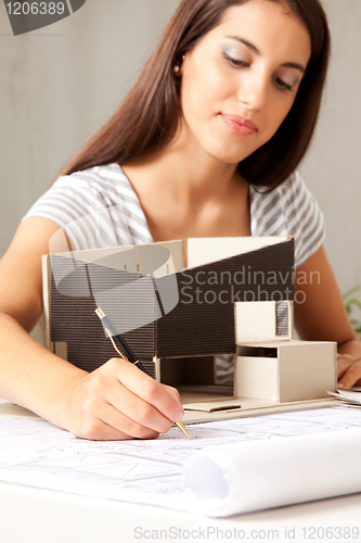 Image of Young Female Architect with Model house