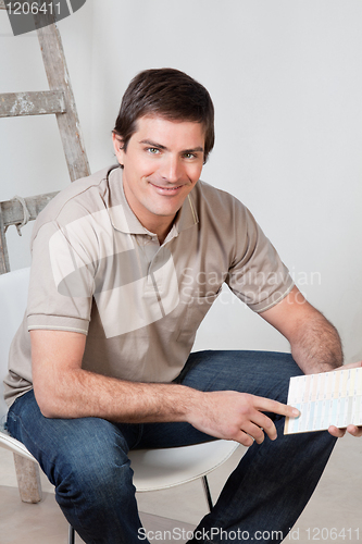 Image of Mature man holding color swatch in his hand