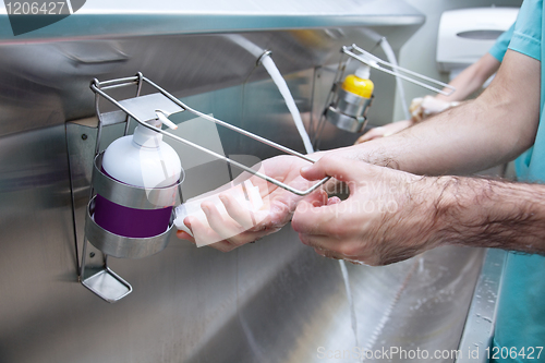 Image of Man washing his hand with hand sanitizer