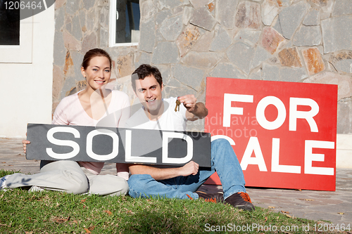 Image of Happy young couple with key to their new house