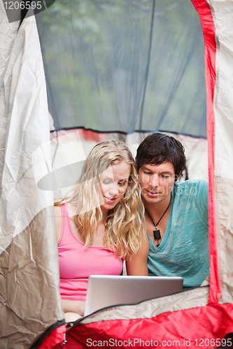 Image of Couple working on laptop while camping