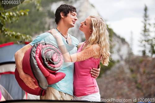 Image of Romantic couple with sleeping bag while camping