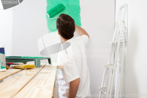 Image of Man painting the wall with roller