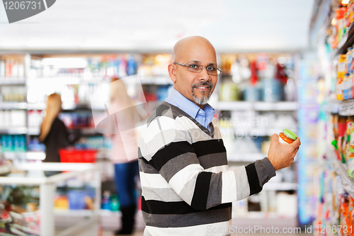 Image of Smiling mature man shopping in the supermarket