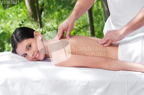 Image of Happy young woman getting massage from a therapist