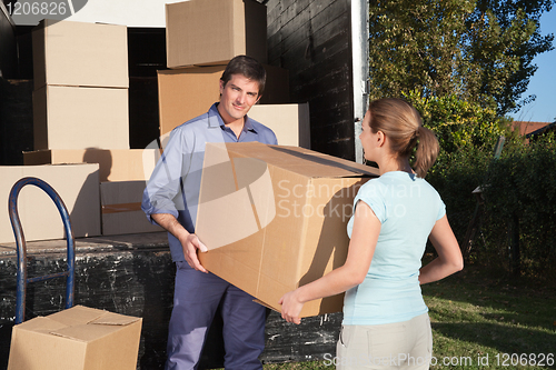 Image of Couple carrying box into the truck