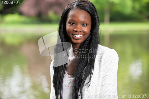Image of Young woman smiling against blurred background